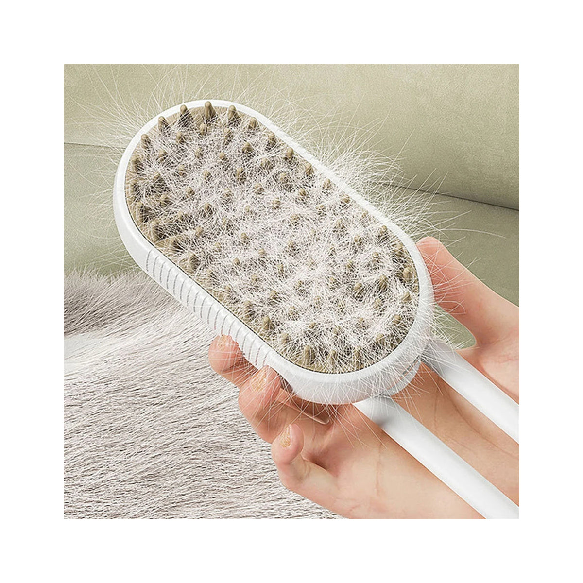 White steam brush held in a hand, its bristle pad packed with shed grey fur, beside a pet resting on a couch