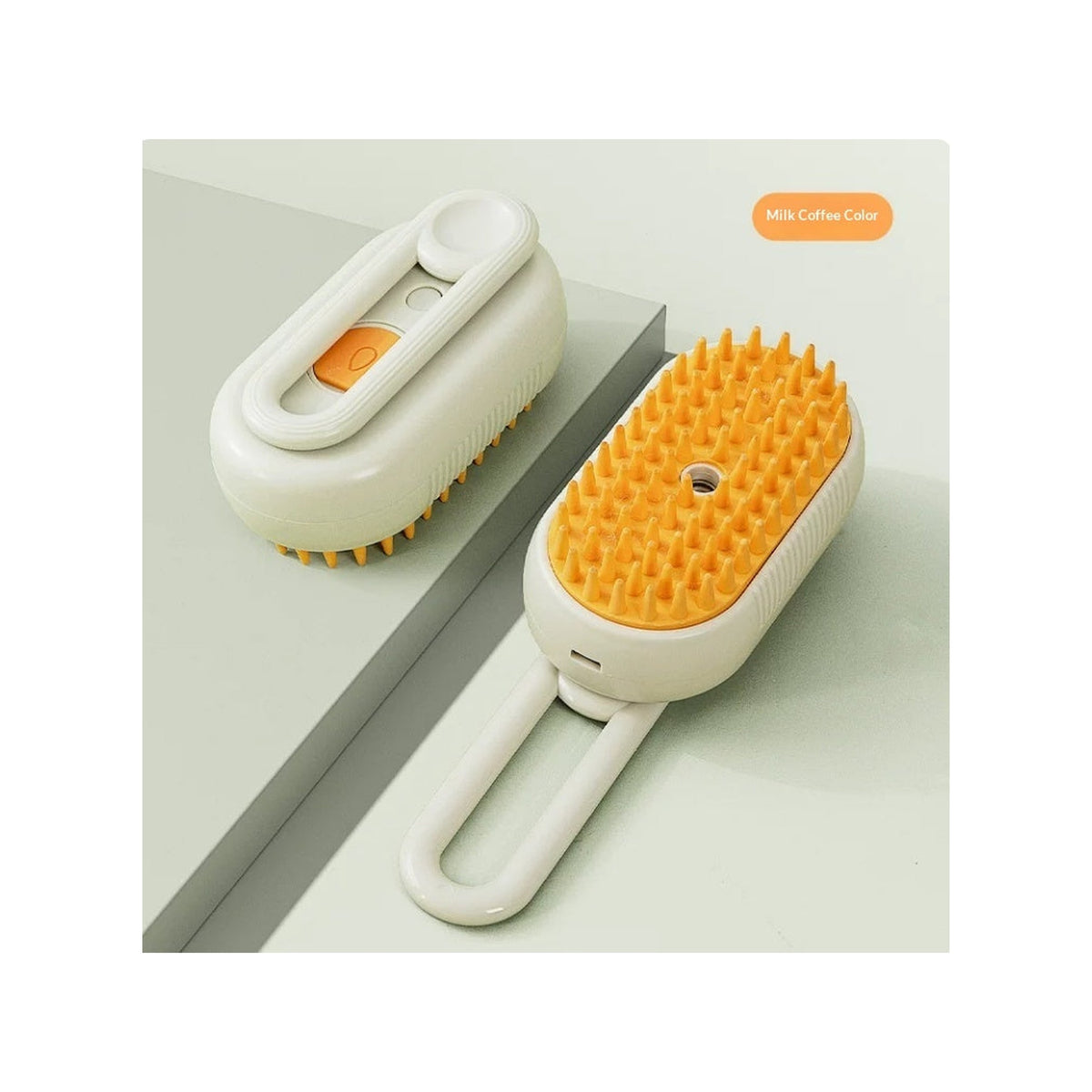 Two cream steam brushes with amber bristle pads on a sage green surface, one from the handle side and one from the bristle side, labelled as the milk coffee colourway