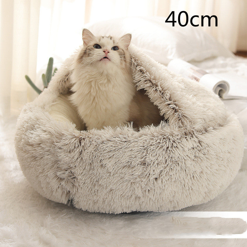 Cream and brown plush round bed with the hood raised behind a long-haired white cat sitting in the opening, the option size printed in the corner