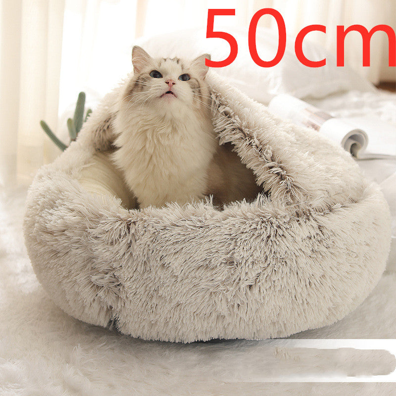 Cream and brown plush round bed with the hood raised behind a long-haired white cat, photographed on a white rug with the option size printed in the corner