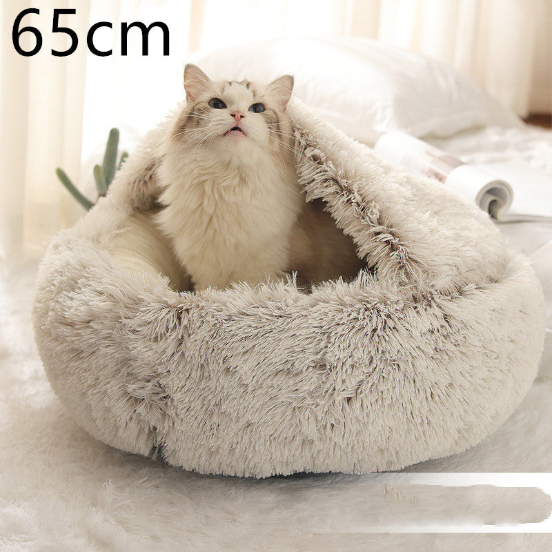 Cream and brown plush round bed with the hood raised behind a long-haired white cat, shown beside a folded magazine with the option size printed in the corner