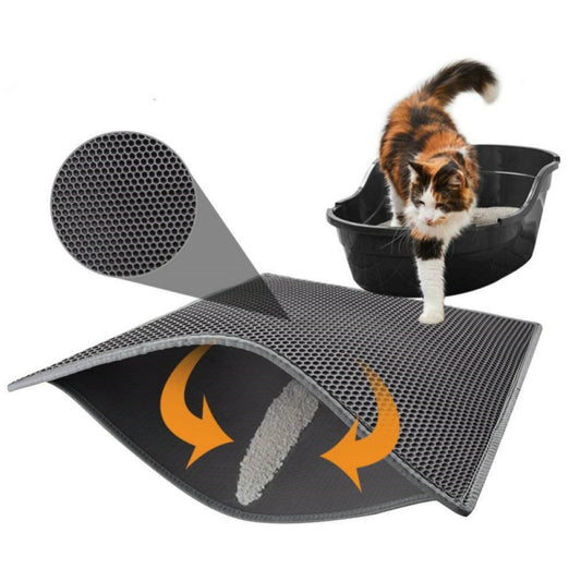 Grey honeycomb litter mat with a magnified inset of its perforated top layer and arrows showing litter falling through, beside a calico cat stepping out of a black litter tray