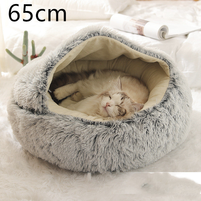 Grey plush round pet bed with the hood raised and a cat curled asleep on the cream lining, the option size printed in the corner