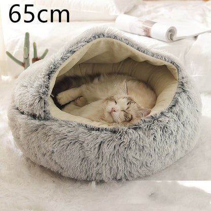 Grey plush round pet bed with the hood raised and a cat curled asleep on the cream lining, the option size printed in the corner