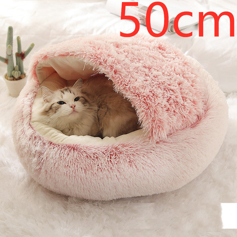 Pink plush round pet bed with the hood raised into an arch over the cream lining and a cat lying inside, the option size printed in the corner