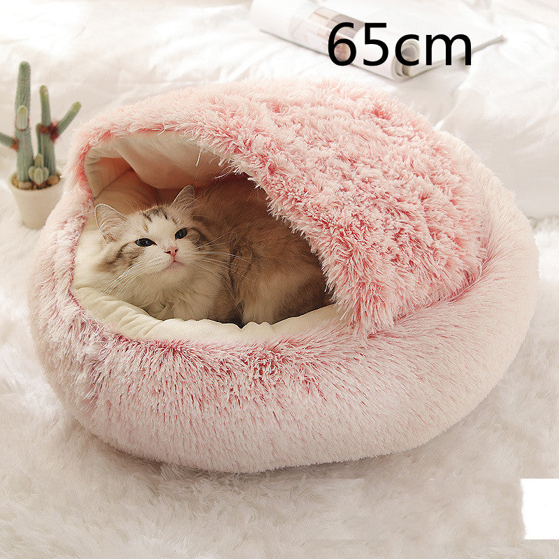 Pink plush round pet bed with the hood arched over the cream lining and a cat looking out, the option size printed in the corner